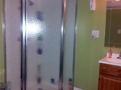 a shower with a glass door in a bathroom at The Wayfaring Buckeye Hostel in Columbus