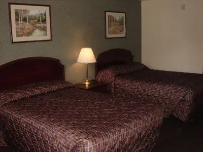 a hotel room with two beds and a lamp at German Village Inn Motel in Columbus