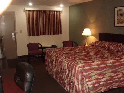 a hotel room with a bed and a table and chairs at German Village Inn Motel in Columbus