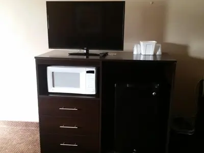 a microwave and a tv on top of a dresser at German Village Inn Motel in Columbus