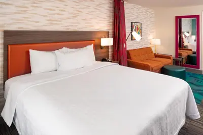 a bedroom with a large white bed and a chair at Home2 Suites By Hilton Columbus/West, OH in Columbus