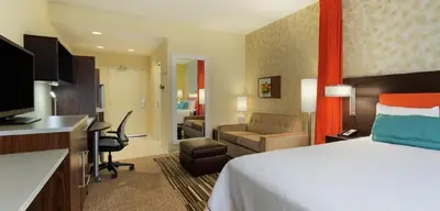 a hotel room with a bed and a living room at Home2 Suites By Hilton Columbus/West, OH in Columbus