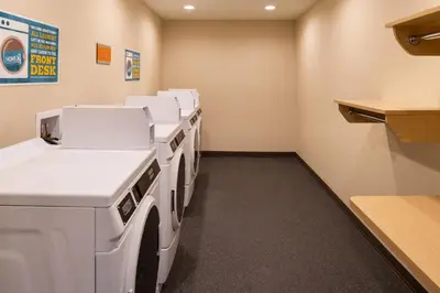 a row of white washing machines in a room at Home2 Suites By Hilton Columbus/West, OH in Columbus