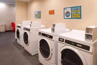 a laundry room with three washing machines in it at Home2 Suites By Hilton Columbus/West, OH in Columbus