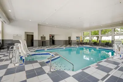 a large swimming pool with chairs in a hotel room at Best Western Suites Columbus in Columbus