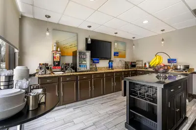 a large kitchen with wooden cabinets and a television at Best Western Suites Columbus in Columbus