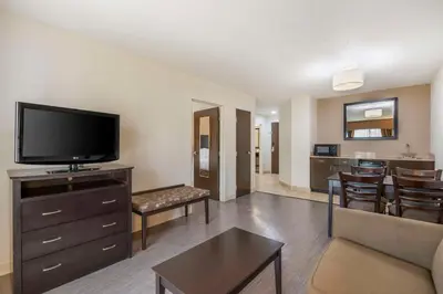 a living room with a flat screen tv and a kitchen at Best Western Suites Columbus in Columbus