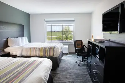 a hotel room with two beds and a flat screen tv at Country Inn & Suites by Radisson, Columbus West, OH in Columbus