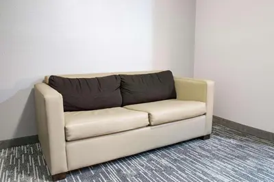 a brown couch in a room with a wall at Country Inn & Suites by Radisson, Columbus West, OH in Columbus