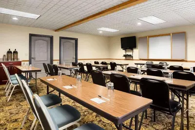 a conference room with tables and chairs and a screen at Country Inn & Suites by Radisson, Columbus West, OH in Columbus
