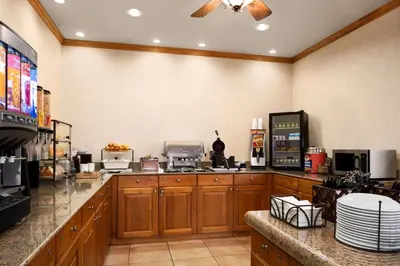 a large kitchen with wooden cabinets and appliances at Country Inn & Suites by Radisson, Columbus West, OH in Columbus