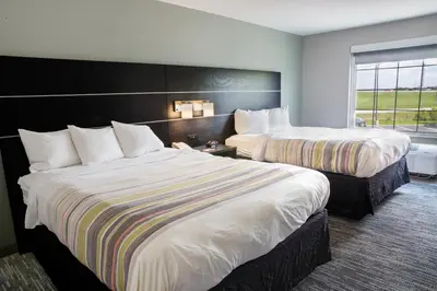 a hotel room with two beds and a window at Country Inn & Suites by Radisson, Columbus West, OH in Columbus