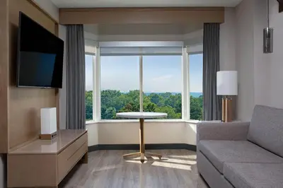 a living room with a couch and a large window at Sheraton Suites Columbus Worthington in Columbus