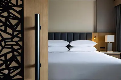 a bedroom with a bed with white sheets and pillows at Sheraton Suites Columbus Worthington in Columbus
