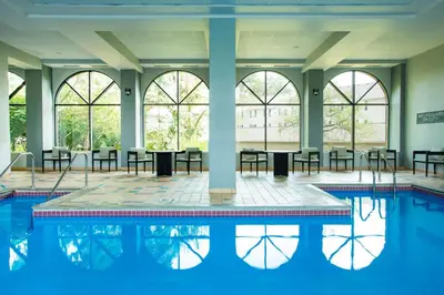 a pool with tables and chairs in a building with windows at Sheraton Suites Columbus Worthington in Columbus
