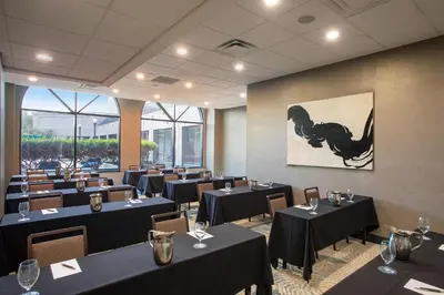 a dining room with black tables and chairs at Sheraton Suites Columbus Worthington in Columbus