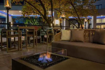 a fire pit in a lobby with a couch and a table at Sheraton Suites Columbus Worthington in Columbus