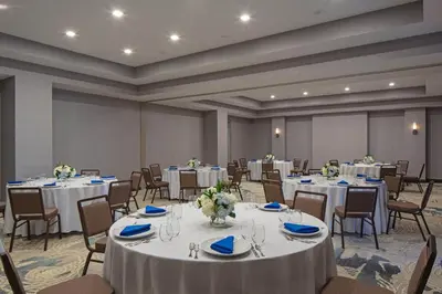 a banquet room with tables and chairs with blue napkins at Sheraton Suites Columbus Worthington in Columbus