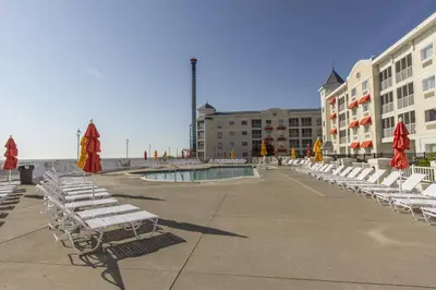 a row of chairs and umbrellas next to a pool at Cedar Point Hotel Breakers in Sandusky