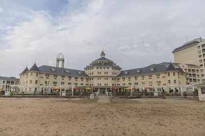 a large building on a beach with buildings at Cedar Point Hotel Breakers in Sandusky