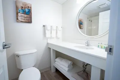 a white bathroom with a sink and a mirror at Cedar Point Hotel Breakers in Sandusky