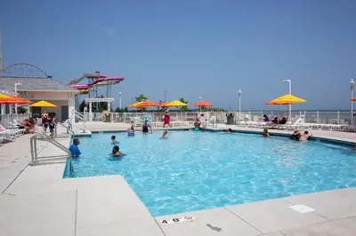 people in a swimming pool with umbrellas at Cedar Point Hotel Breakers in Sandusky