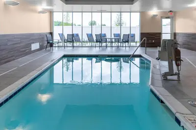 a swimming pool with blue water in a building at Fairfield Inn & Suites Columbus New Albany in New Albany