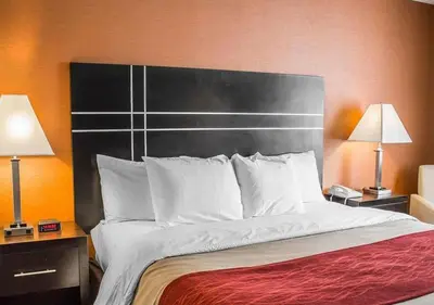 a large bed in a hotel room with two lamps at Howard Johnson by Wyndham Columbus State Fairgrounds I-71 in Columbus