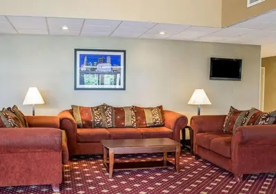 a living room with couches and a tv at Howard Johnson by Wyndham Columbus State Fairgrounds I-71 in Columbus