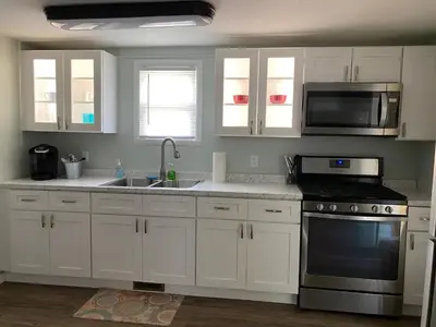 a kitchen with white cabinets and a sink and a microwave at Cozy One Bedroom House in Adrian