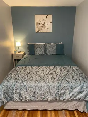 a bedroom with a large bed with a gray comforter at Cozy One Bedroom House in Adrian