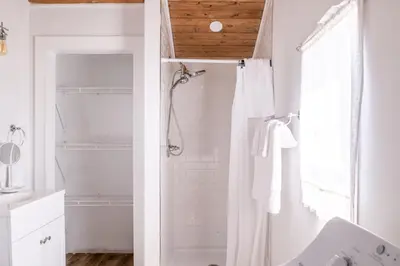 a white bathroom with a shower and a sink at Open Concept Cabin for 2 - Near Ark Encounter! in Williamstown