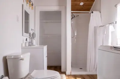 a white bathroom with a toilet and a shower at Open Concept Cabin for 2 - Near Ark Encounter! in Williamstown