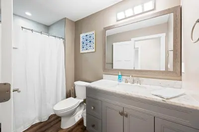 a bathroom with a sink and a toilet and a mirror at Spacious 6BR Near Ark! Ample Parking, 3 Full Baths in Williamstown