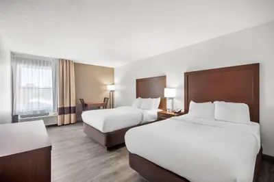a hotel room with two beds and a desk at Comfort Inn & Suites Cincinnati Eastgate in Eastgate