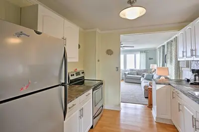 a kitchen with a stainless steel refrigerator and a living room at Waterfront Oak Harbor Home on Lake Erie with Views! in Sand Beach