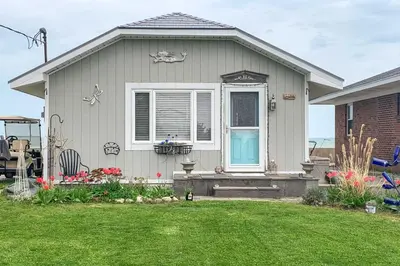 a house with a blue door and a yard at Waterfront Oak Harbor Home on Lake Erie with Views! in Sand Beach