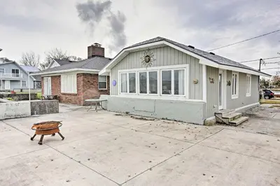 a small white house with a table in a driveway at Waterfront Oak Harbor Home on Lake Erie with Views! in Sand Beach