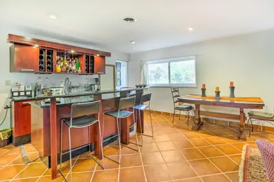 a kitchen with a bar and a table with chairs at Contemporary Cincinnati Apt with WiFi, Near Kenwood! in Cincinnati