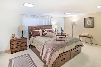 a bedroom with a large bed with a wooden headboard at Contemporary Cincinnati Apt with WiFi, Near Kenwood! in Cincinnati