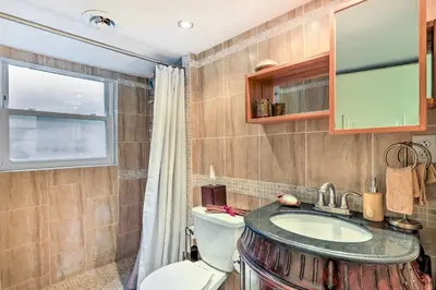a bathroom with a sink and a toilet and a window at Contemporary Cincinnati Apt with WiFi, Near Kenwood! in Cincinnati