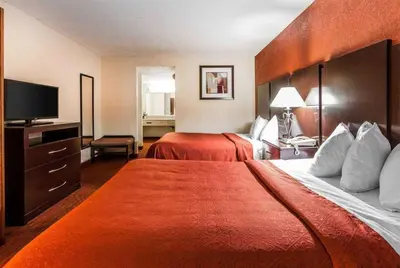 a hotel room with two beds and a flat screen tv at Wingate by Wyndham Marietta Conference Center Ohio in Marietta