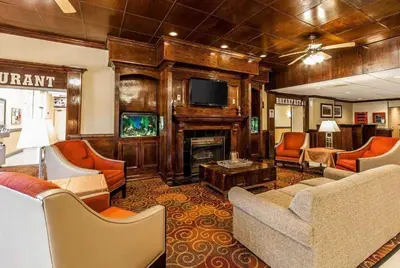 a living room with a couch and a fireplace at Wingate by Wyndham Marietta Conference Center Ohio in Marietta
