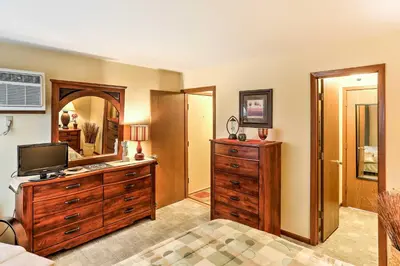 a living room with a dresser and a mirror at Waterfront Port Clinton Condo with Pool Access! in Port Clinton