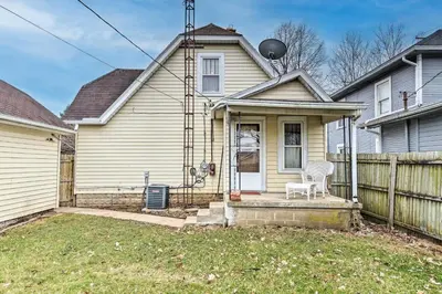a house with a white chair in the front yard at Charming Urbana Home Near Downtown! in Urbana