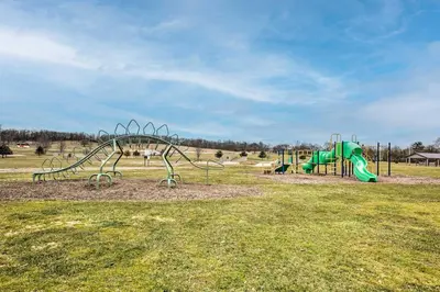 a playground with a green slide in a field at Charming Urbana Home Near Downtown! in Urbana