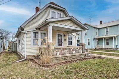 a small white house with a fence in the yard at Charming Urbana Home Near Downtown! in Urbana