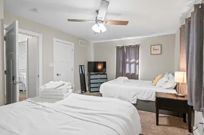 a bedroom with two white beds and a desk at 4BR, 3Bath for 11, Near Ark, Plenty of Free Parking in Williamstown