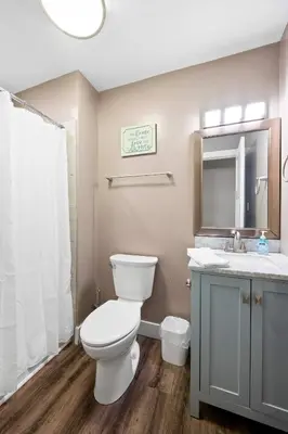 a bathroom with a toilet and a sink and a mirror at 4BR, 3Bath for 11, Near Ark, Plenty of Free Parking in Williamstown