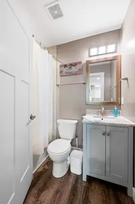 a bathroom with a toilet and a sink and a mirror at 4BR, 3Bath for 11, Near Ark, Plenty of Free Parking in Williamstown